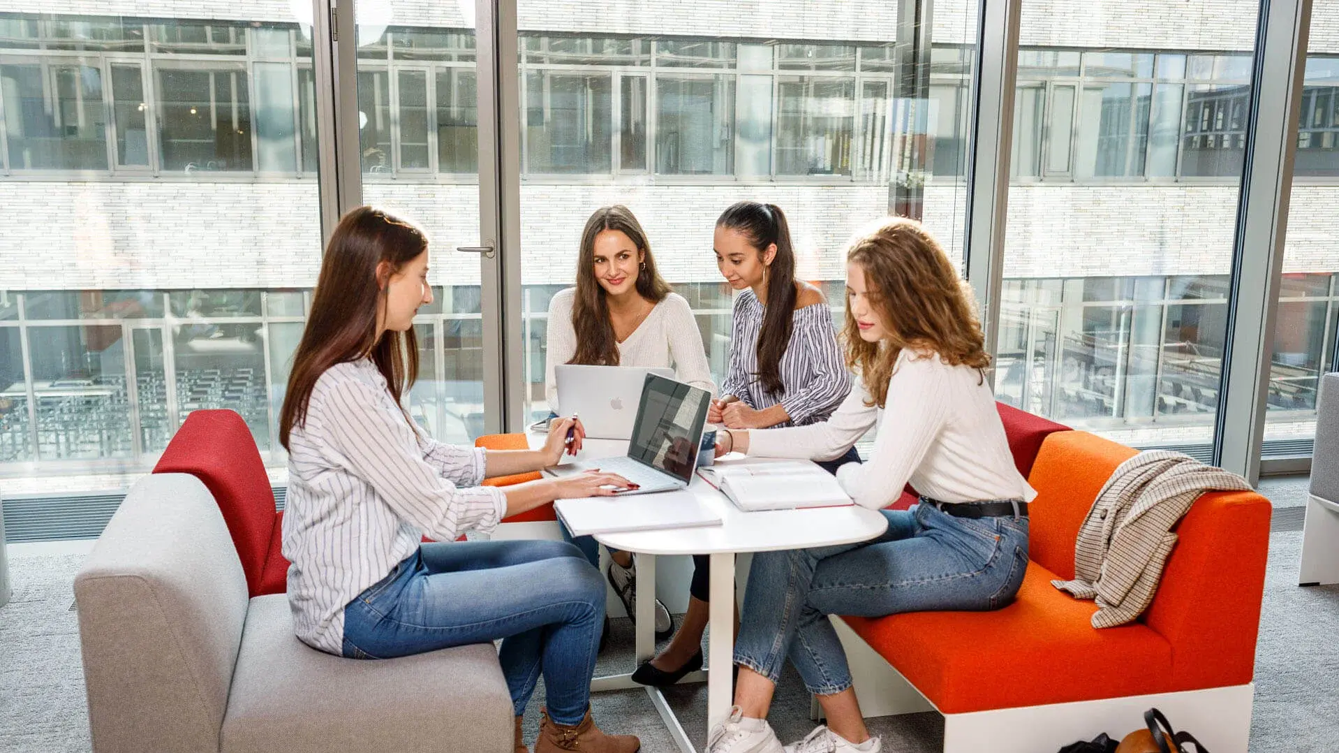 [Translate to German:] Six students sitting and smiling