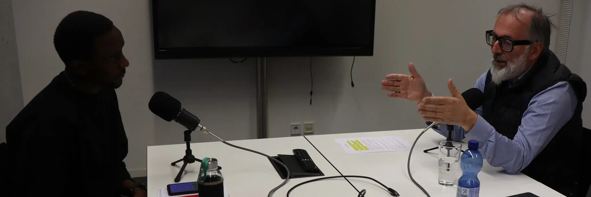 Norbert Niederkofler sitting at a table with a student recording a podcast.