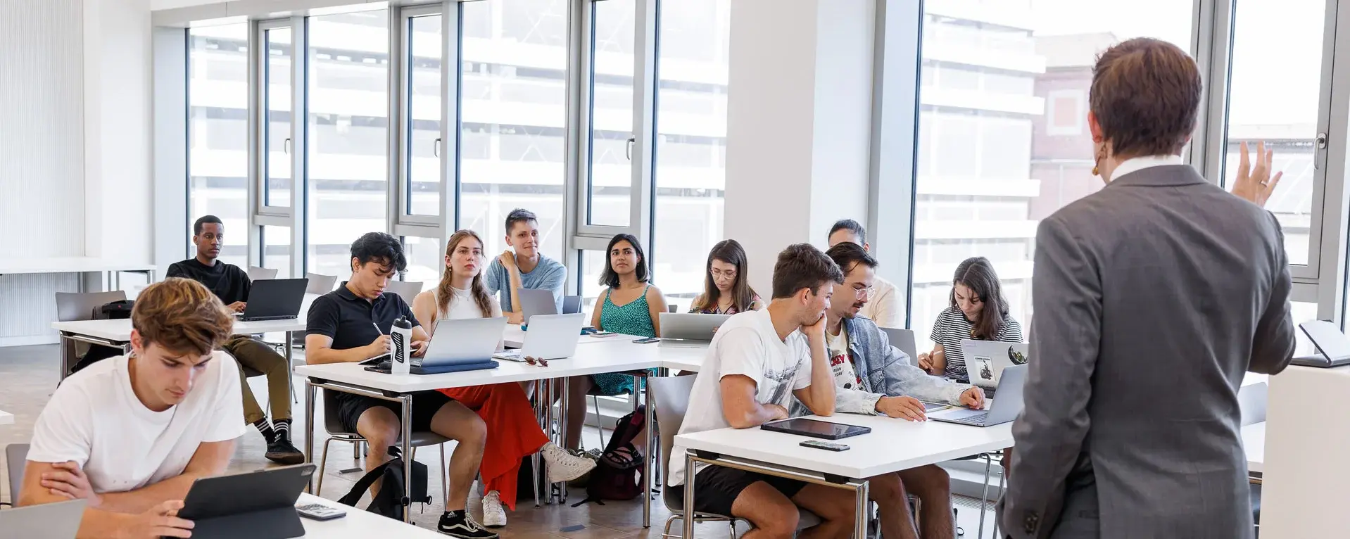 Professor hält eine Vorlesung vor einem vollen Klassenraum mit Studenten