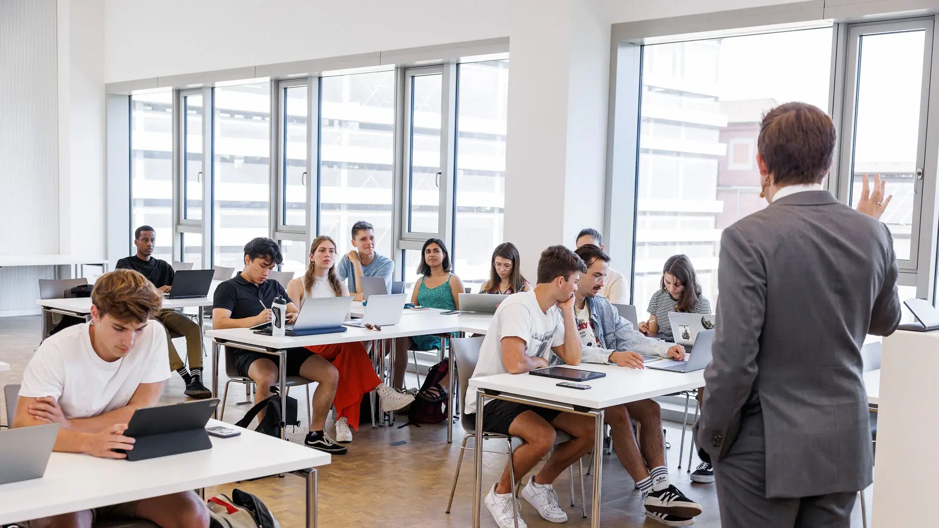 Professor hält eine Vorlesung vor einem vollen Klassenraum mit Studenten