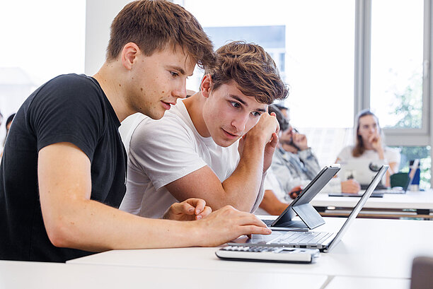 Zwei Studenten arbeiten gemeinsam an Laptops