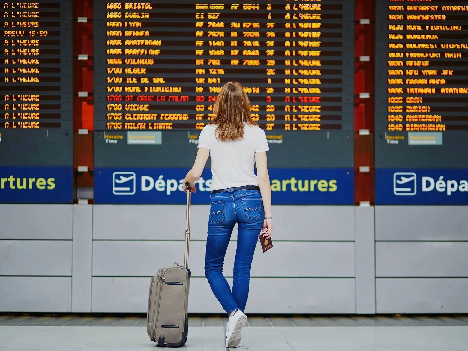 [Translate to German:] Young woman in international airport