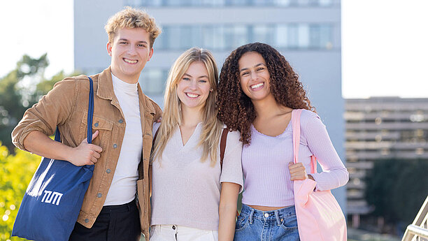 Drei Studenten posieren auf dem Campus