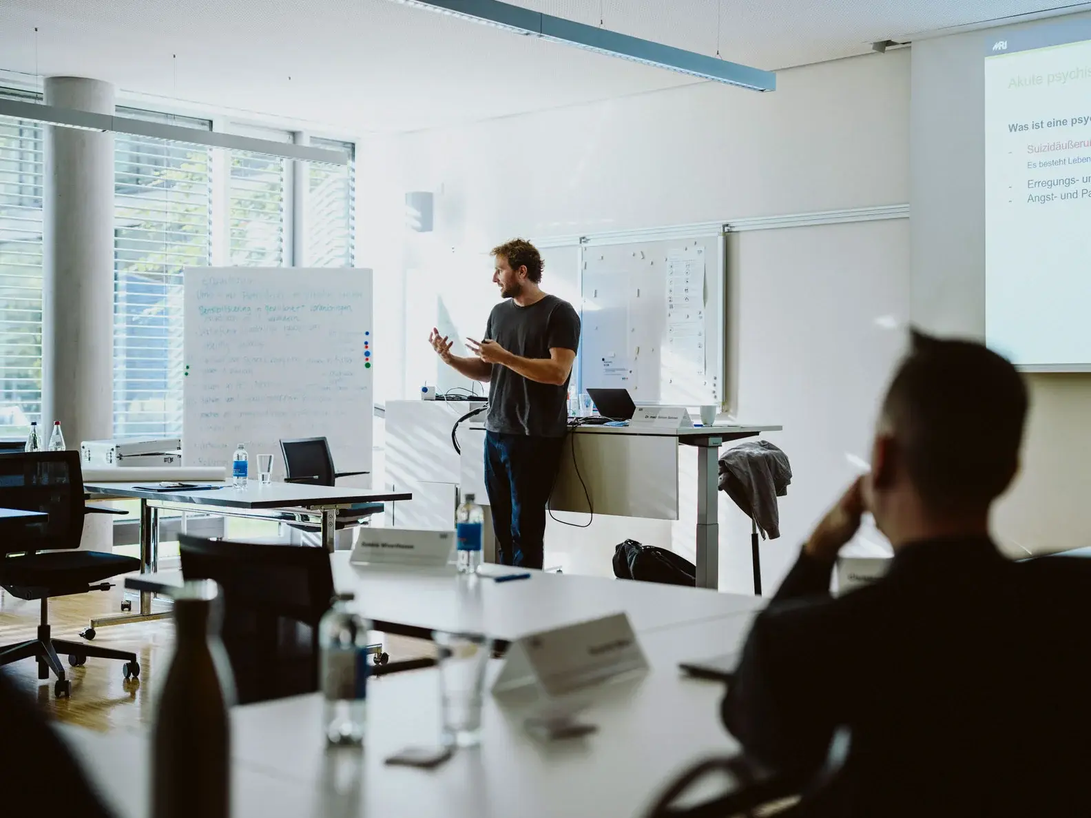 [Translate to German:] Man presenting in a class room