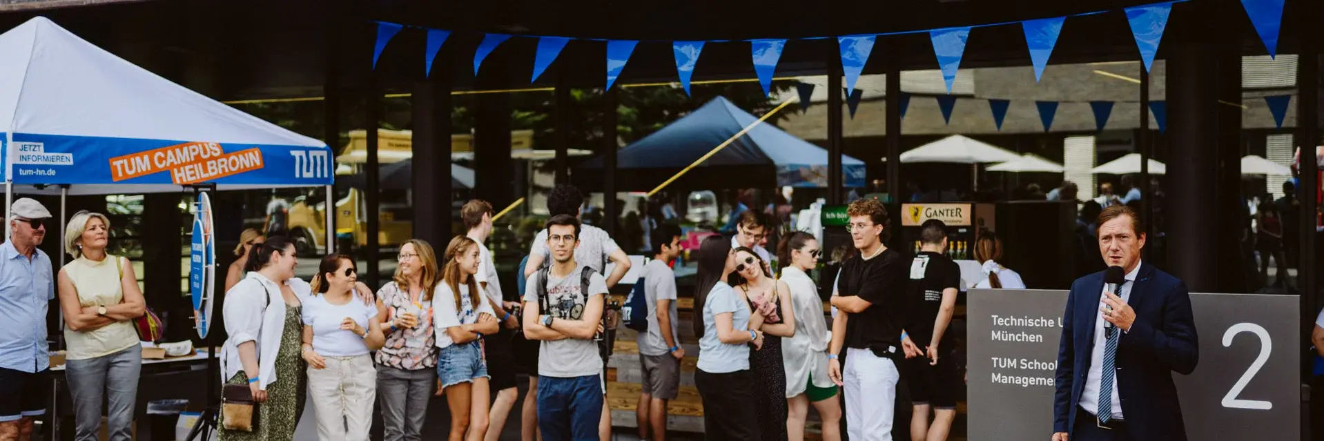 Studenten vor dem Campus-Gebäude bei einer Veranstaltung