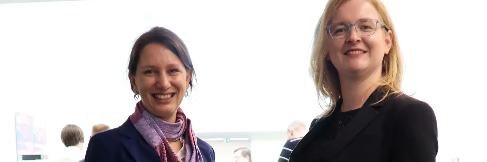 [Translate to German:] two formally dressed women standing