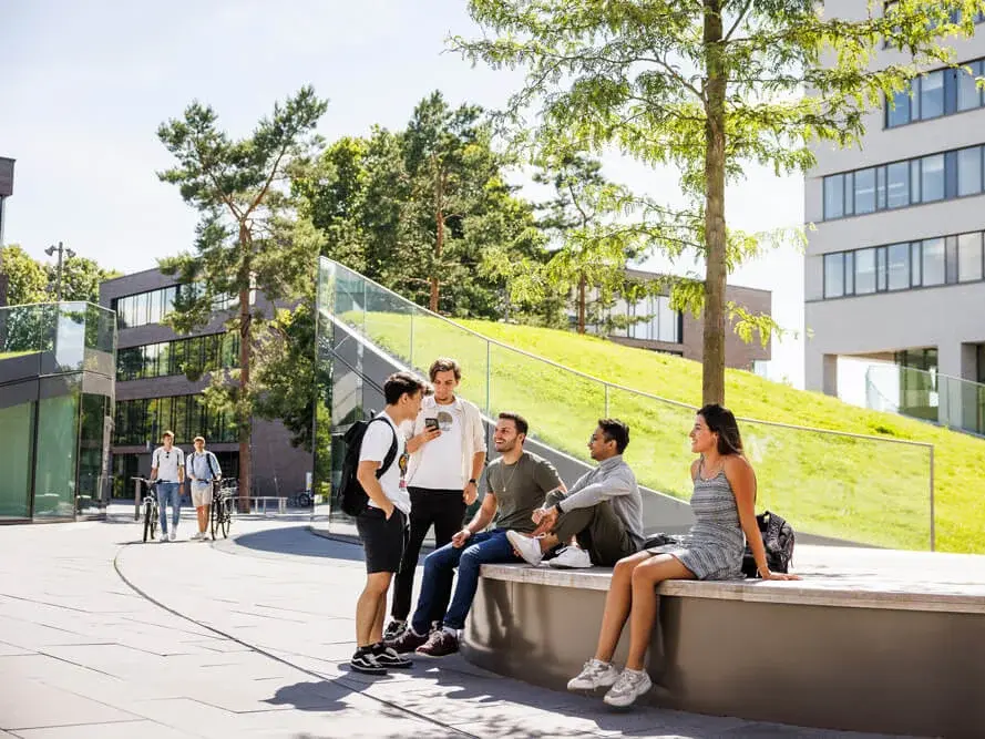 Studenten im Gespräch vor der Mensa auf dem Campus