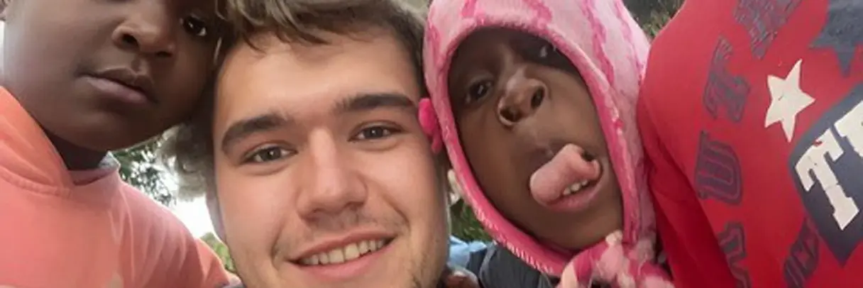 [Translate to German:] kids and a man looking into the camera having fun