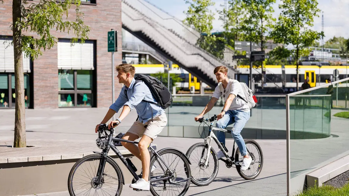 Two people riding bikes at campus